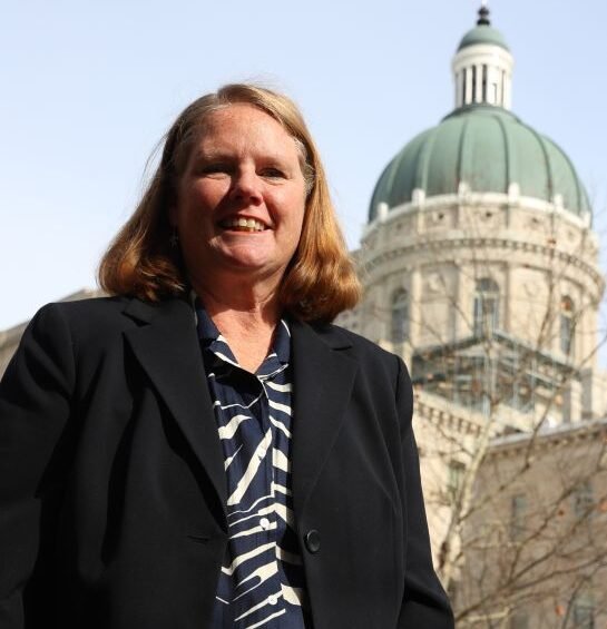Dr. Cinde Wirth smiles while standing outside the Indiana Statehouse.